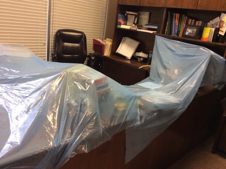 Desk covered with tarp leaking roof